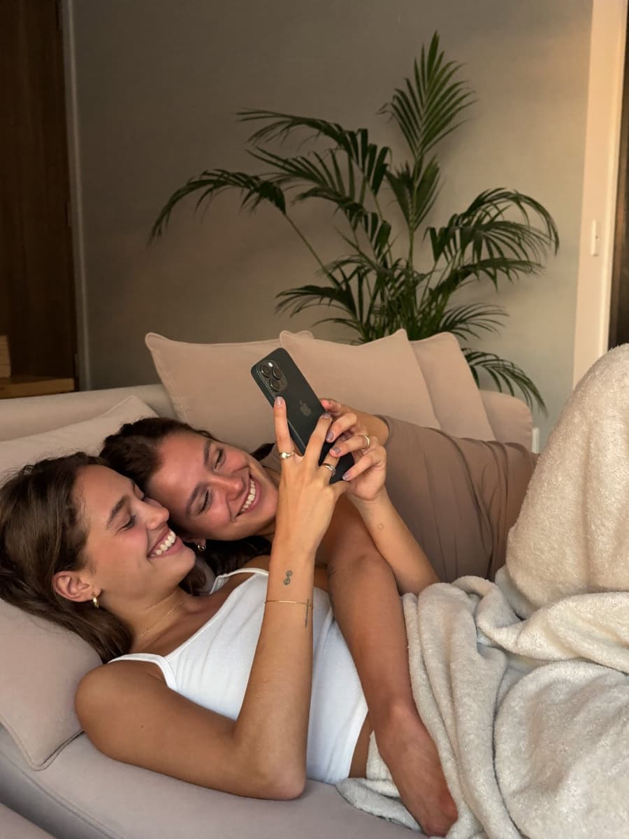 Young couple relaxing on a sofa, looking at a phone together